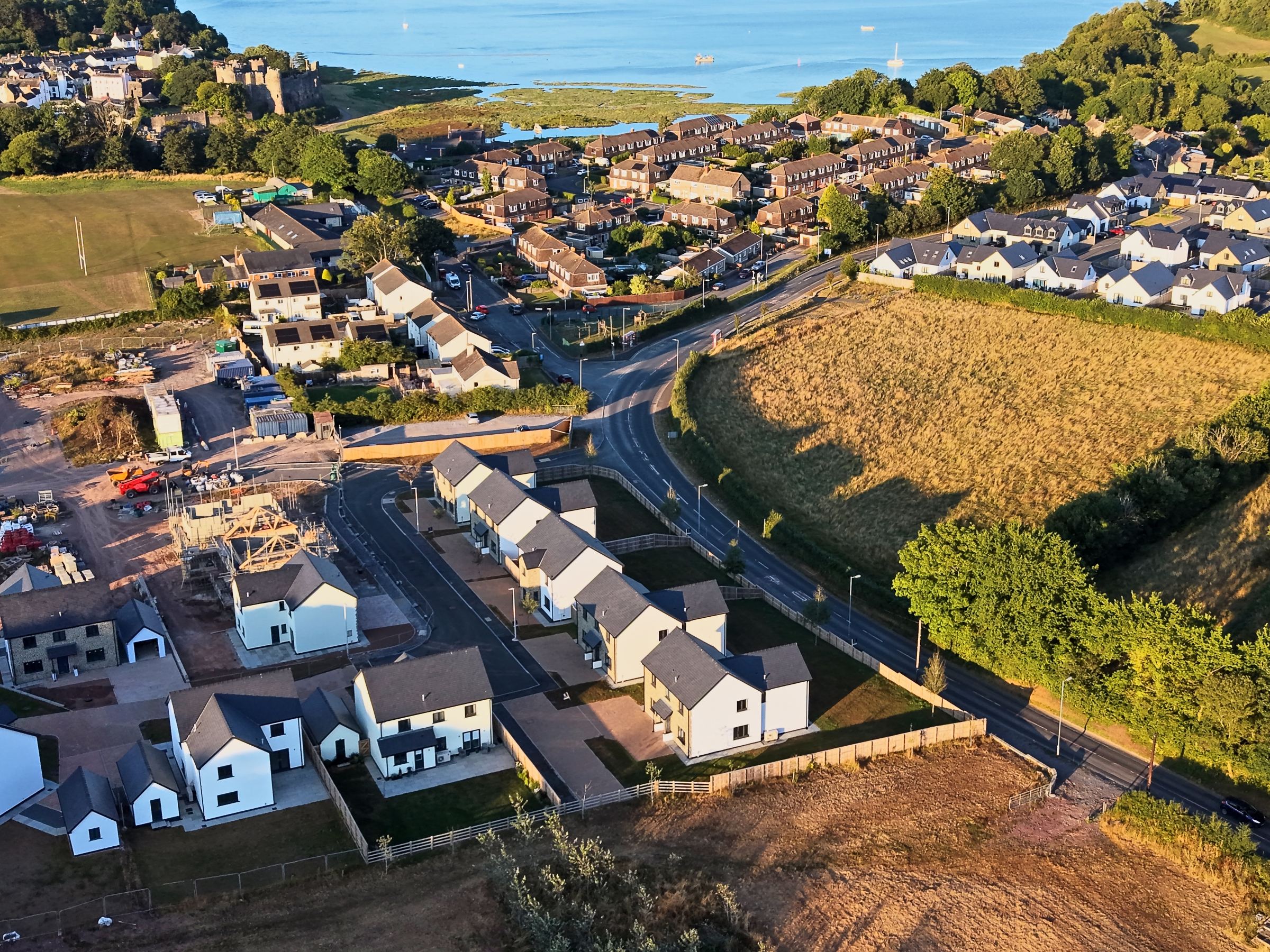 Cl&ocirc;s Hugdon, Laugharne &mdash; the development above the estuary in golden evening light