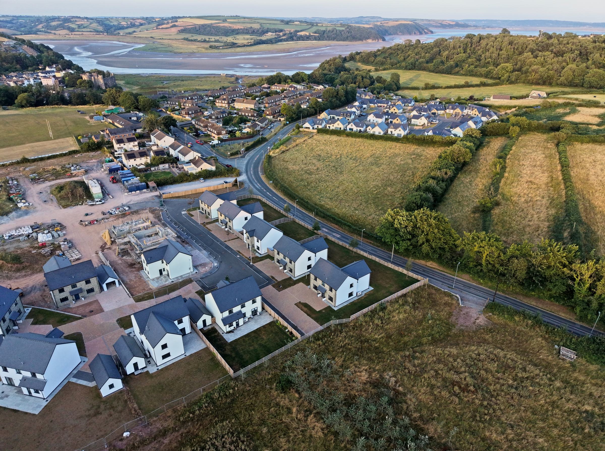Cl&ocirc;s Hugdon, Laugharne &mdash; the homes and development road with the T&acirc;f estuary beyond