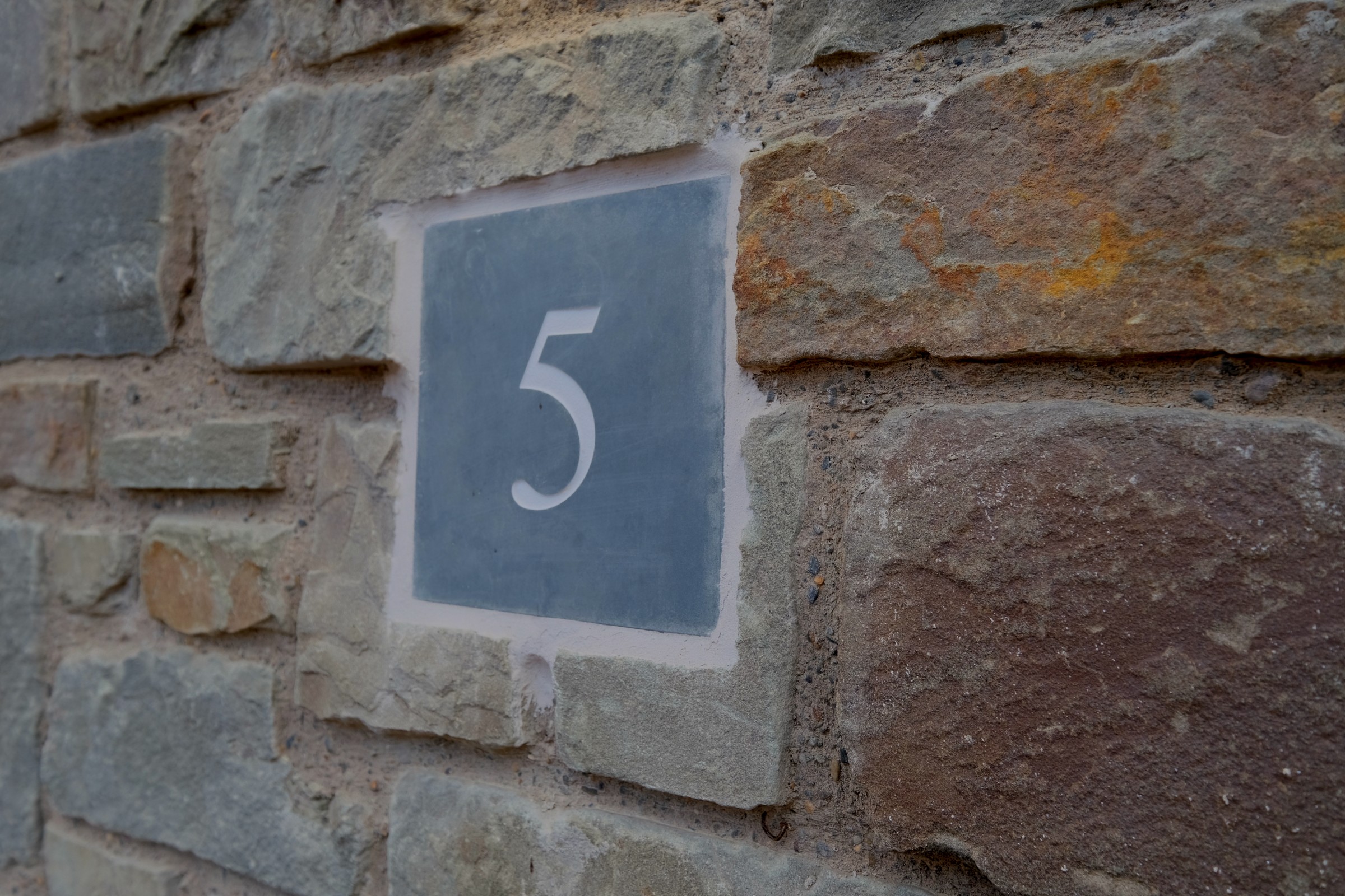 House 5, The Oak &mdash; the slate house-number plaque, a Sancler detail